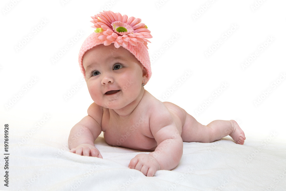 Funny female newborn with nice pink crocheted cap on white background. Happy baby girl with nice knitted pinky cap on white fur blanket. Newborn wearing cute knitted cap with big flower. Funny female newborn with nice pink crocheted cap on white background. Happy baby girl with nice knitted pinky cap on white fur blanket. Newborn wearing cute knitted cap with big flower.