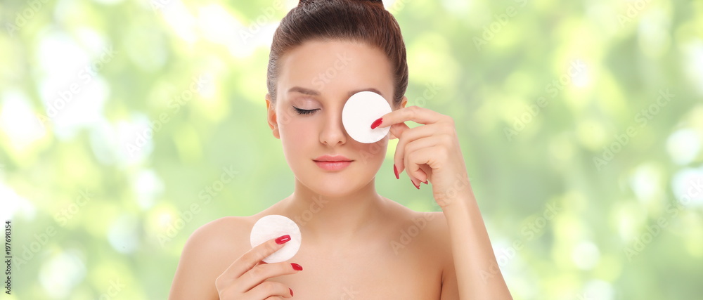 Beautiful woman cleans the face with cotton swab Beautiful woman cleans the face with cotton swab