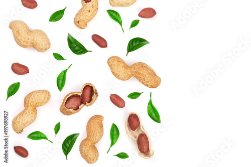 Peanuts with shells decorated with green leaves isolated on white background with copy space for your text, top view