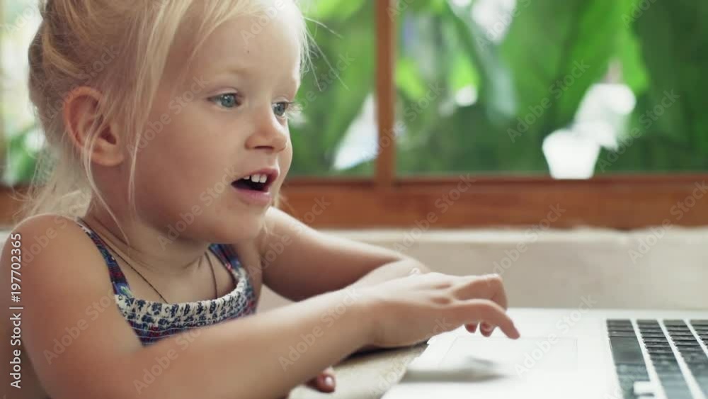 Surprised blonde baby girl using laptop in sunny cafe rapid slow motion Surprised blonde baby girl using laptop in sunny cafe rapid slow motion