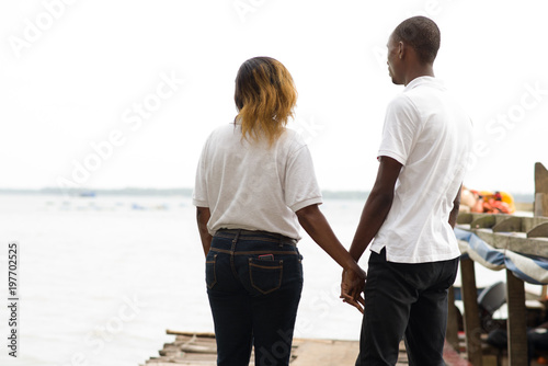 young couple standing on a dock at the edge of the lagoon.