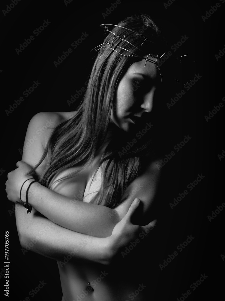 sexy beautiful woman with a wreath of barbed wire on the head on a dark background. black and white sexy beautiful woman with a wreath of barbed wire on the head on a dark background. black and white