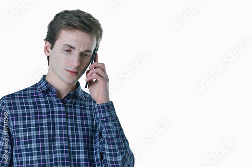 Closeup portrait of young, serious business man, corporate employee, student talking on cell phone.