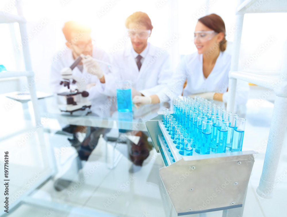 background image of scientists studying blue liquid in a flask