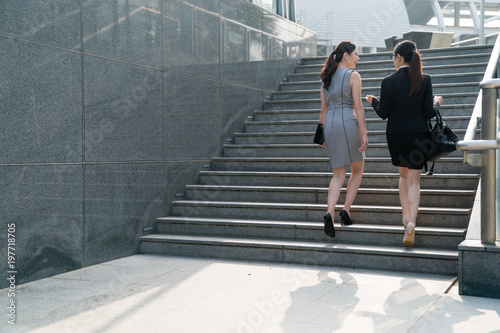 businesswomen walking up stair.