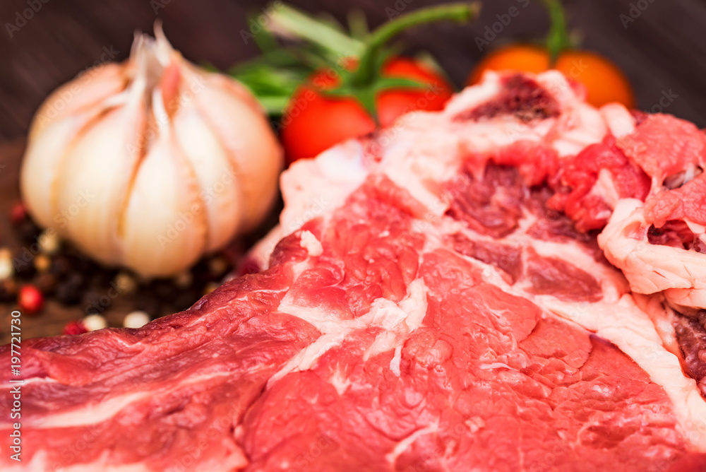 Raw beef steak with pepper, herbs and tomatoes Raw beef steak with pepper, herbs and tomatoes
