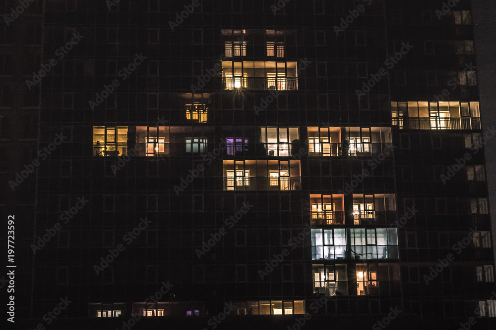 a facade of a building with windows with blue and yellow light in them at night a facade of a building with windows with blue and yellow light in them at night