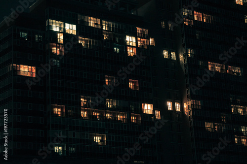 a facade of a building with windows with blue and yellow light in them at night