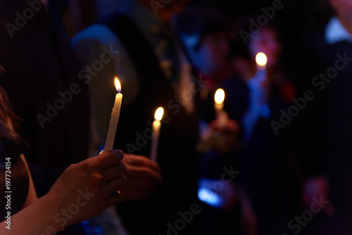 People hold candles light at dark scene photo