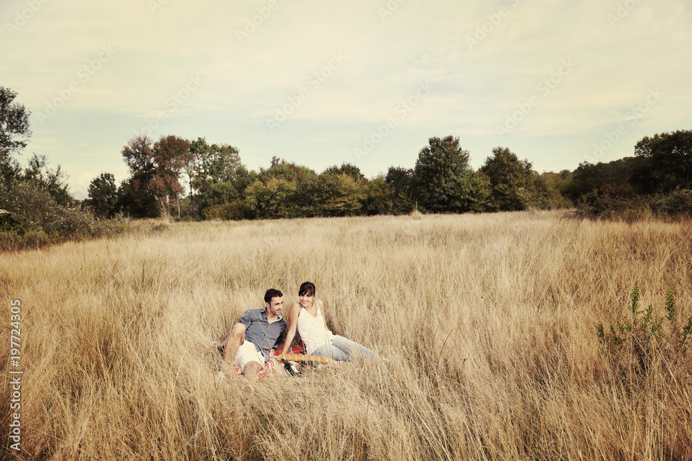 happy couple enjoying countryside picnic in long grass happy couple enjoying countryside picnic in long grass