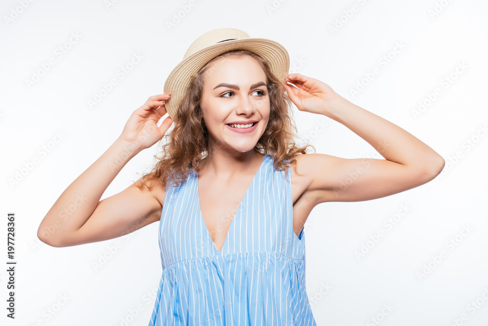Portrait of a smiling attractive woman in summer dress and hat posing while standing and looking at camera isolated over white background Portrait of a smiling attractive woman in summer dress and hat posing while standing and looking at camera isolated over white background