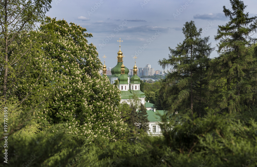 Botanical garden with blooming lilac, spring landscape, St. George Cathedral of the Vydubychi Monastery, view on Dnipro river, Kyiv, Ukraine