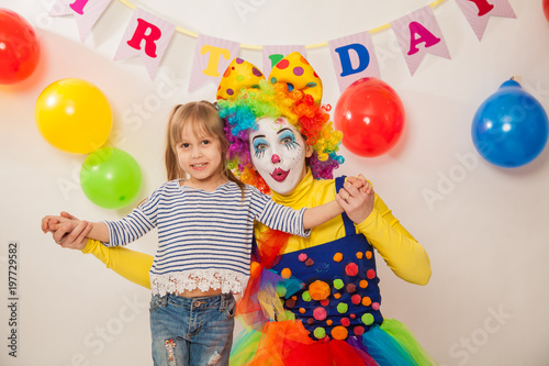 clown girl on the birthday of a child. A party for a child. Emotional Child fools around