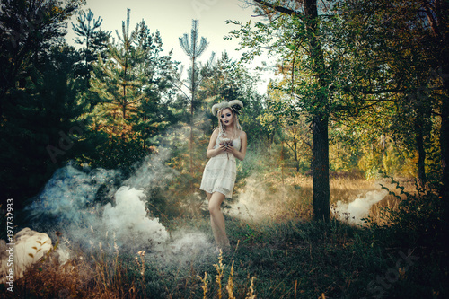 Beautiful model is posing in a forest with white horns 