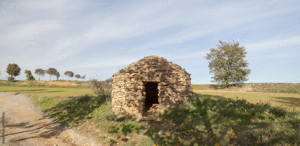 Landscape with construction for agricultural use. Stonecraft, Barraca de vinya, or caseta de pedra seca. Typical mediterranean rural structure. Sant Fruitos del Bages,Catalonia,Spain.