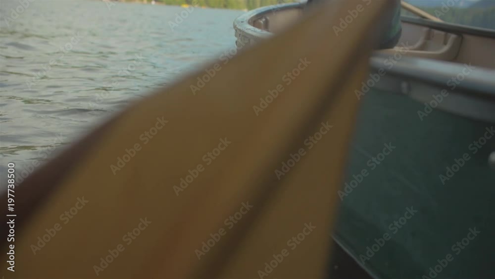 Close up shot of a rowing paddle on a drifting boat