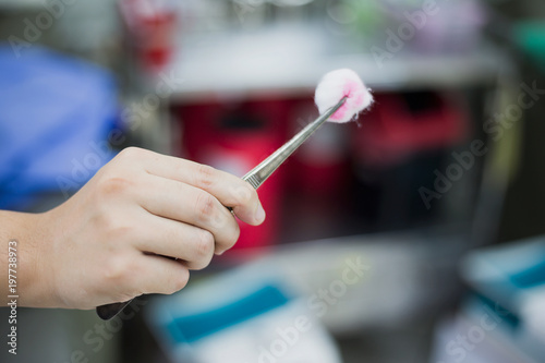 The doctor is using a cotton swab moistened with alcohol to wound the patient.