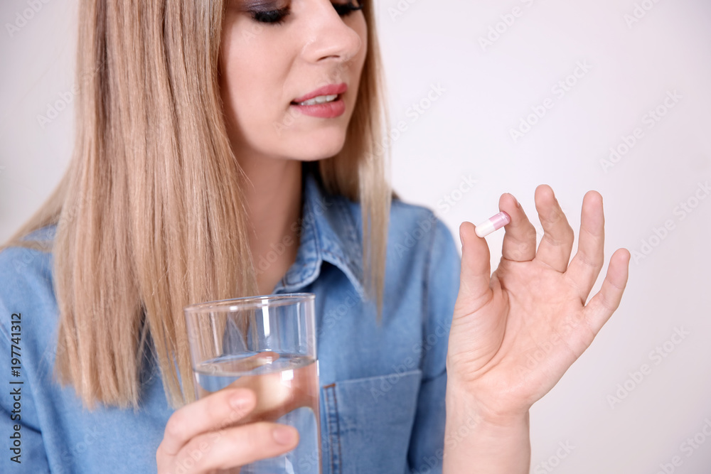 Young woman with pill indoors Young woman with pill indoors