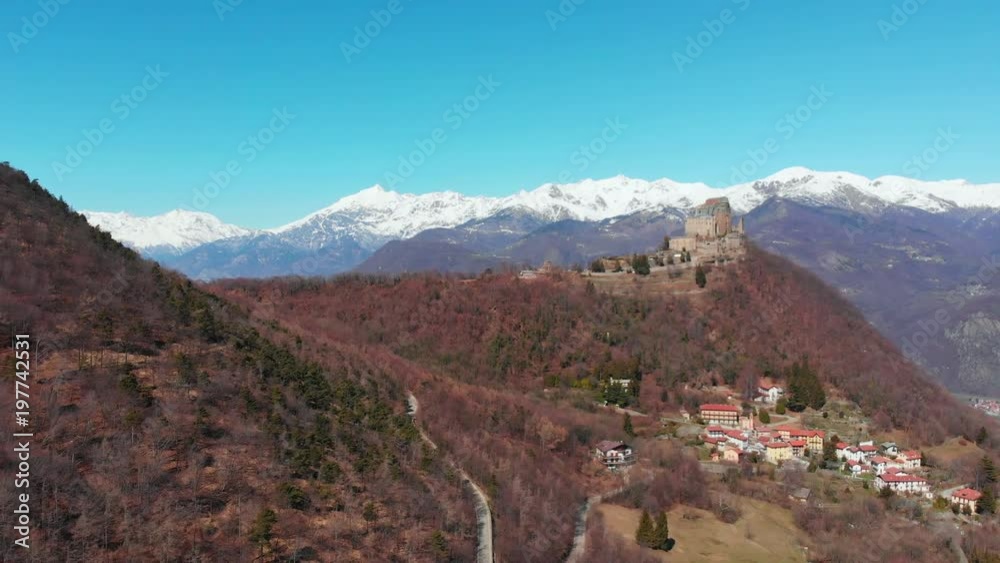 Aerial: drone flying over forest reveals snow capped mountains and Sacra di San Michele (Saint Michel Abbey) on top, Turin, Italy Aerial: drone flying over forest reveals snow capped mountains and Sacra di San Michele (Saint Michel Abbey) on top, Turin, Italy