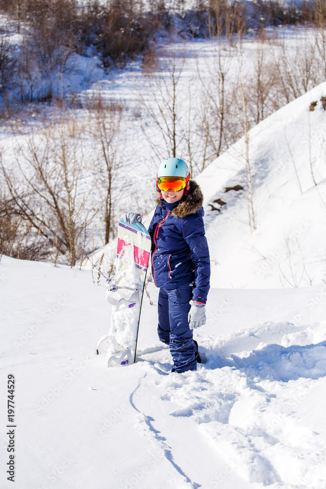 Image of female athlete wearing helmet with snowboard standing in park