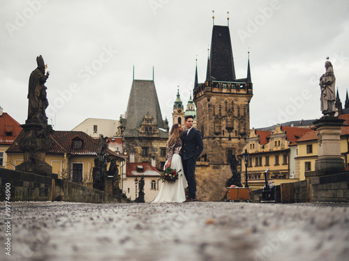 Groom and bride in charles bridge. winter wedding in Prague