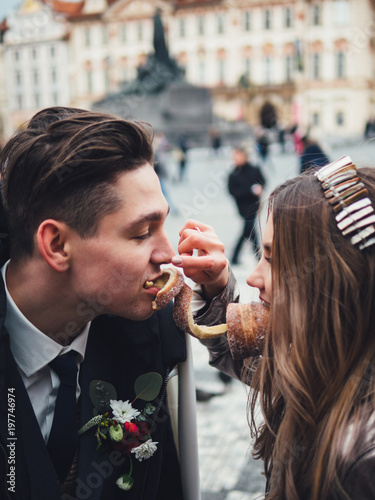 Photography Groom and bride with trdelnik in historic centre of Prague
