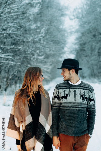 young couple relaxing in a winter forest photo