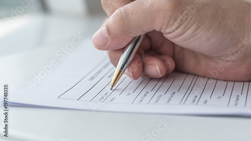 Applicant filling in company application form document applying for job, or registering claim for health insurance photo