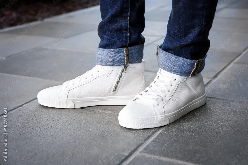 Stylish man in white shoes on city street