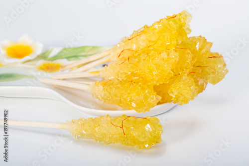 Close Up Of Saffron Rock Candy Sugar Crystal in A White Plate Isolated on White Background It Is Often Used To Be Dissolved In Tea In Iranian & Persian Cuisine photo
