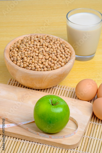 green apple, soy milk, egg and soy seeds in wooden bowl with tapeline © Chanoknaree