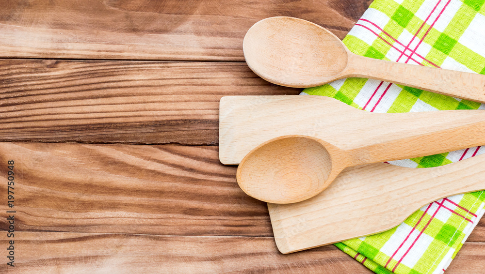 Wooden spoons and wooden spade with kitchen towel on the table. Top view. Copy space. Wooden spoons and wooden spade with kitchen towel on the table. Top view. Copy space.