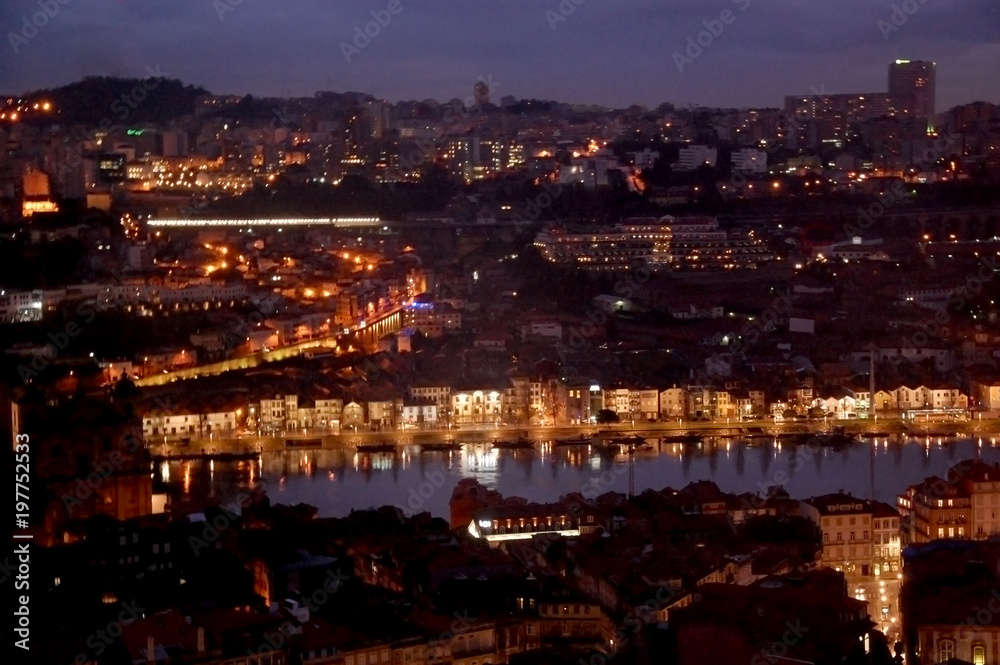 Night panoramic view of the Porto city center and the Douro river with the lights reflections in the water