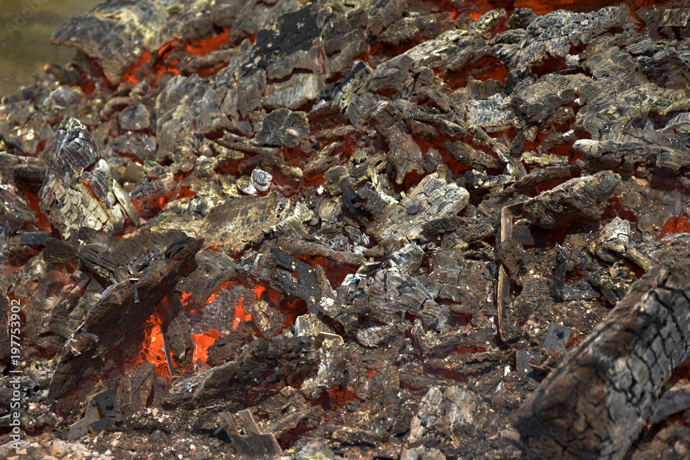 Remnants of burning wooden crates. Burning fire. The smoldering fireplace.