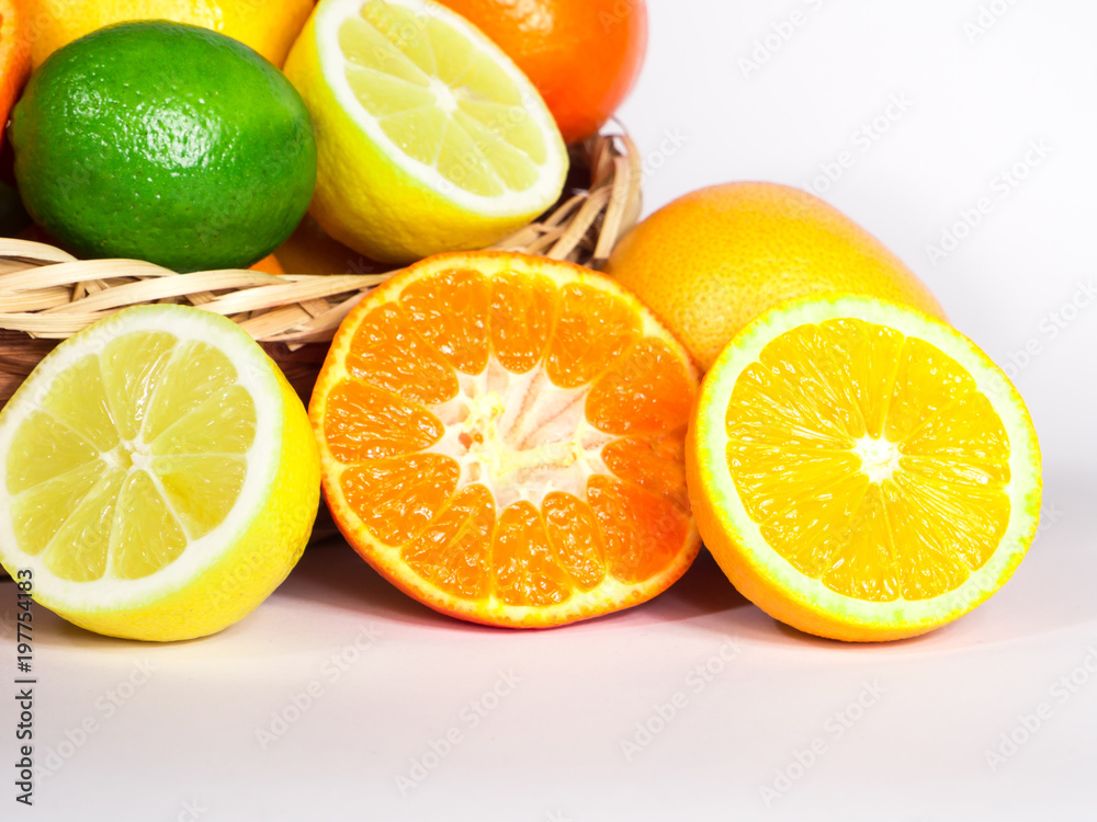 Basket of fresh colorful citrus fruits ready to be squeezed for healthy breakfast. Fruits are captured from different angles over white background. Basket of fresh colorful citrus fruits ready to be squeezed for healthy breakfast. Fruits are captured from different angles over white background.