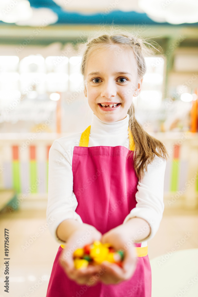 Little girl holds in hands handmade caramel sweets Little girl holds in hands handmade caramel sweets