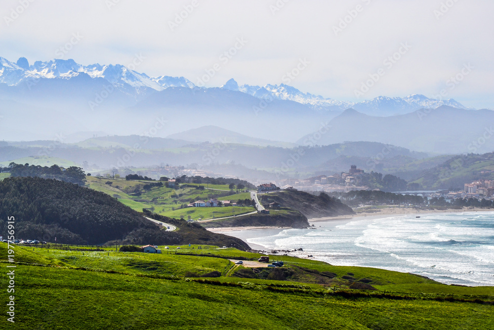 Landscape near Oyambre Beach, in San Vicente de la Barquera, Cantabria, Spain. At the bottom, the Picos de Europa Mountains