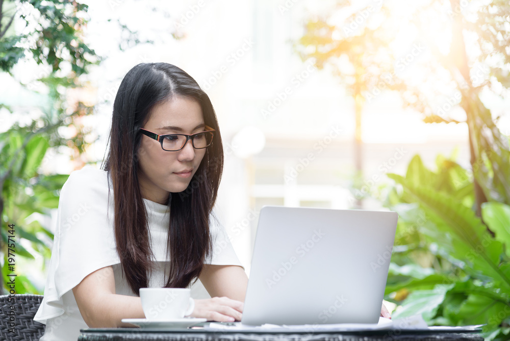 Beautiful asian attractive woman has working and typing on laptop computer for business marketing at coffee cafe in the morning with happy and relaxing time. Beautiful asian attractive woman has working and typing on laptop computer for business marketing at coffee cafe in the morning with happy and relaxing time.