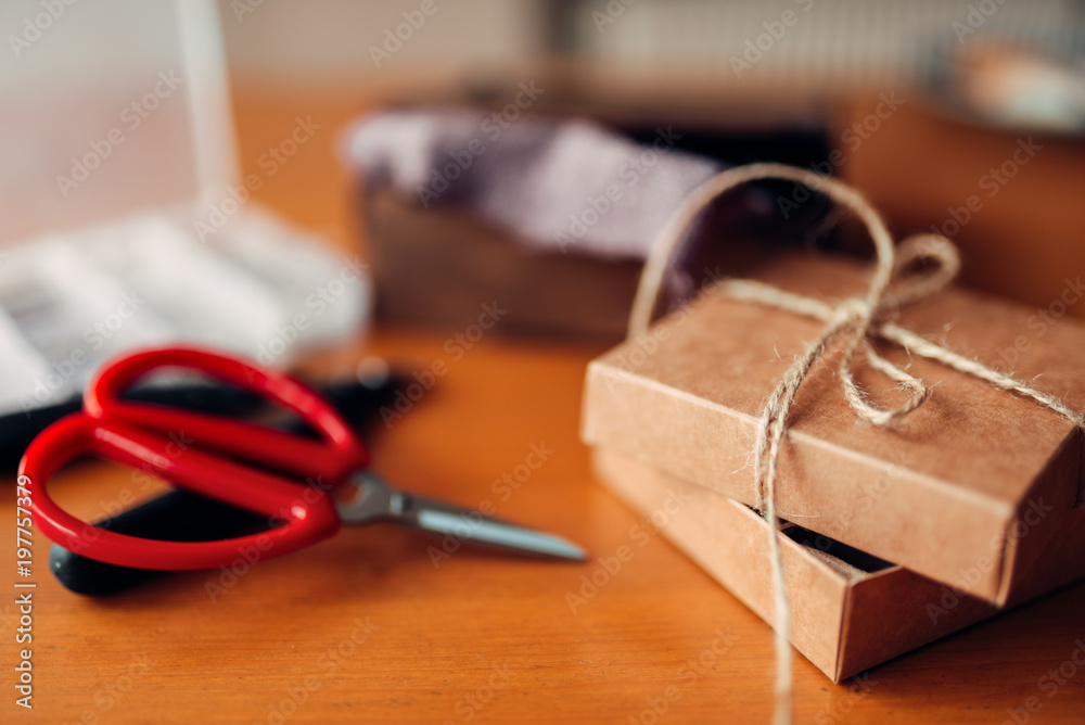 Needlework gift and scissors on wooden table Needlework gift and scissors on wooden table