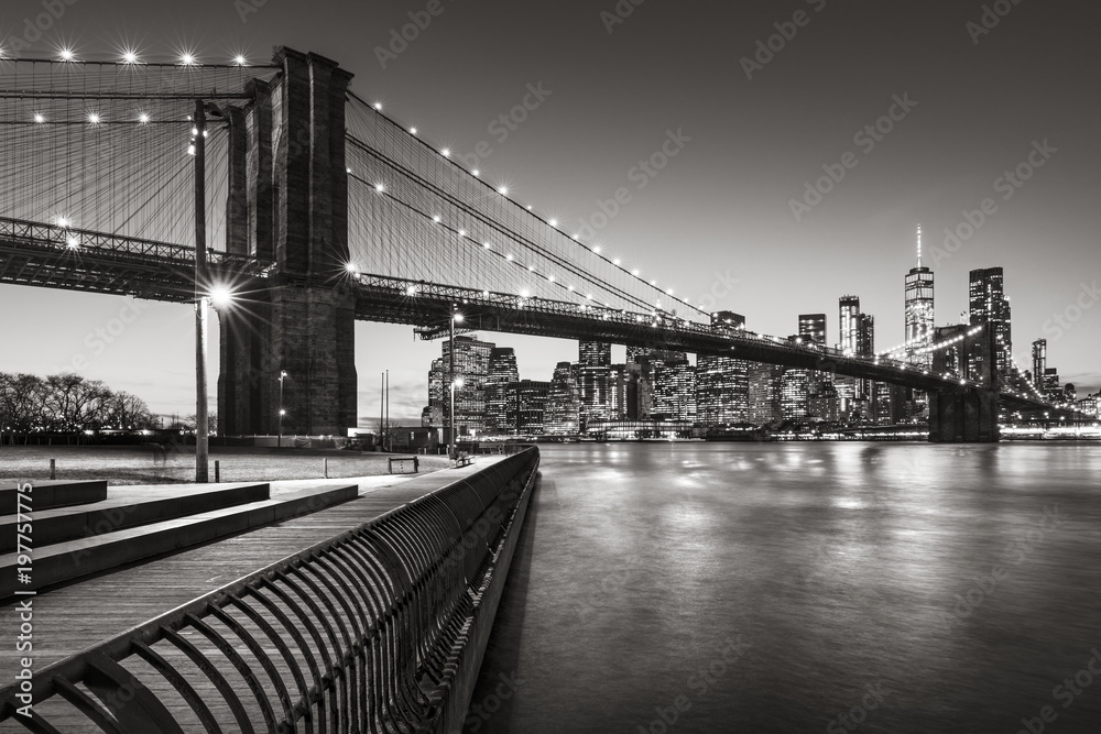 Brooklyn Bridge Park boardwalk in evening with the skyscrapers of Lower Manhattan, East River, and the Brooklyn Bridge in Black & White. Brooklyn, New York City - obrazy, fototapety, plakaty 