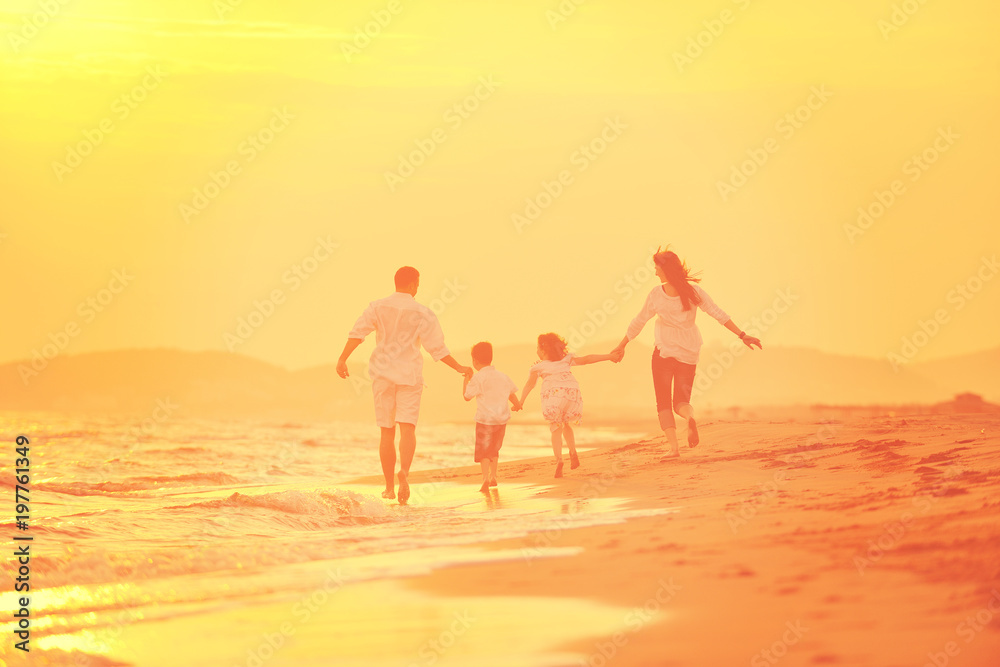 happy young family have fun on beach at sunset