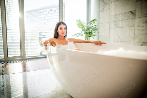 Beautiful woman taking hot bath in a luxury bathroom