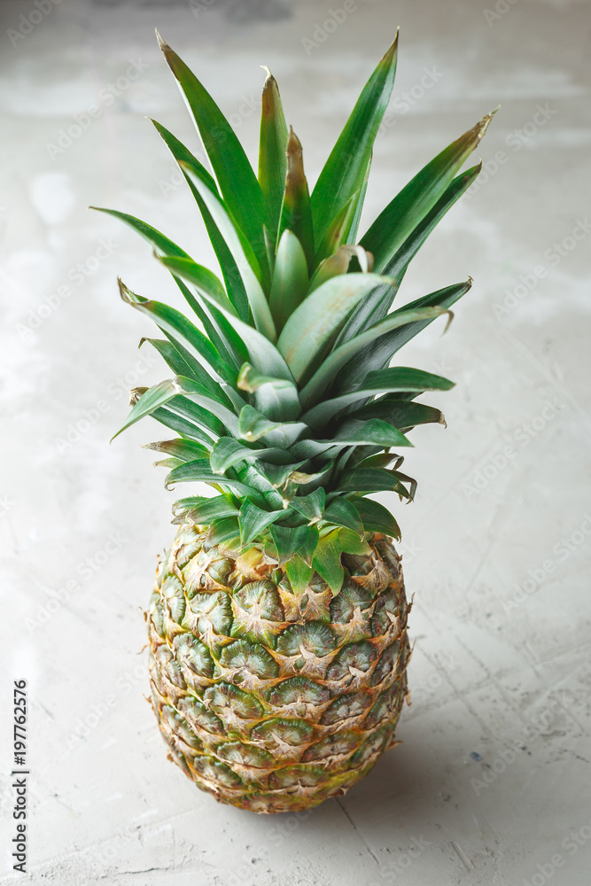 Fototapeta premium Whole pineapple fruit on grey concrete background