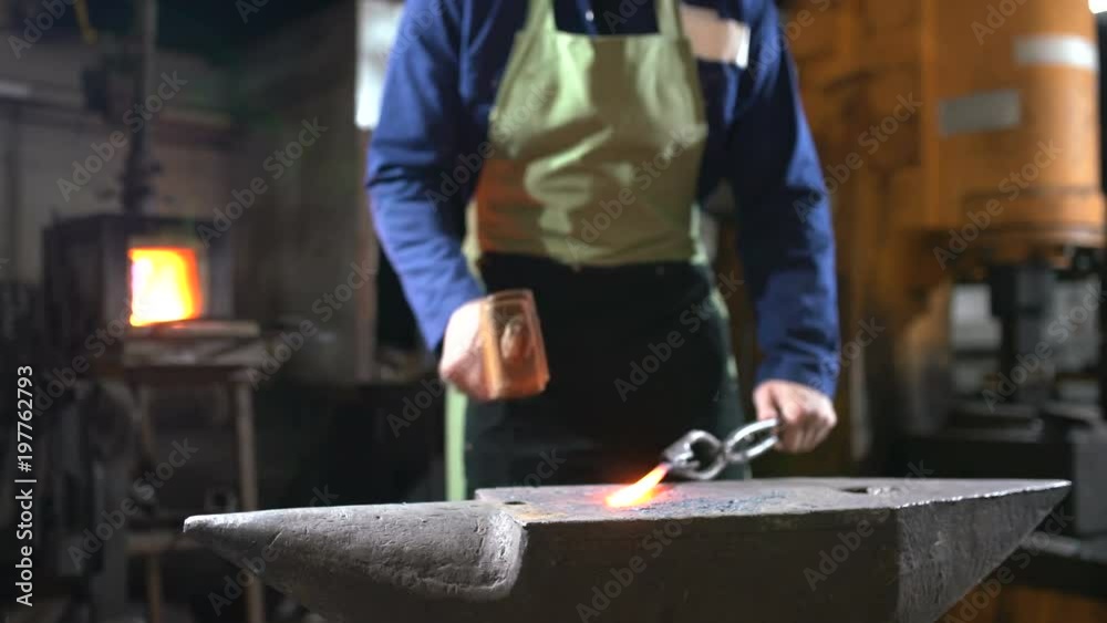 The blacksmith forges the luminous metal in the furnace, kicks out the sparks The blacksmith forges the luminous metal in the furnace, kicks out the sparks