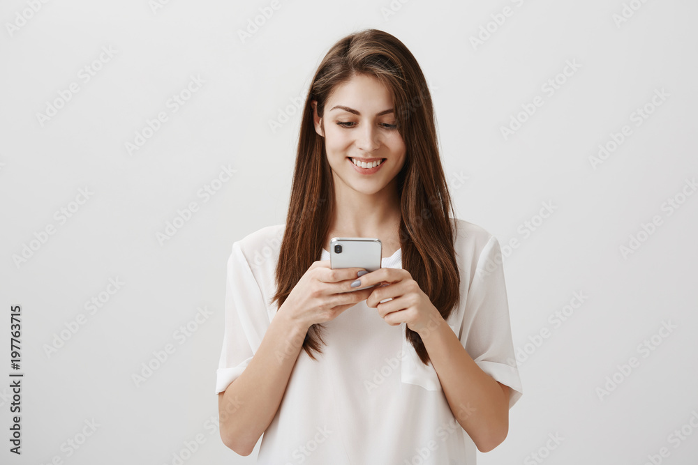 Girl received lots of likes under new post. Popular attractive caucasian female student holding smartphone, looking at screen with excitement, typing answer or reading feedback about new project Girl received lots of likes under new post. Popular attractive caucasian female student holding smartphone, looking at screen with excitement, typing answer or reading feedback about new project
