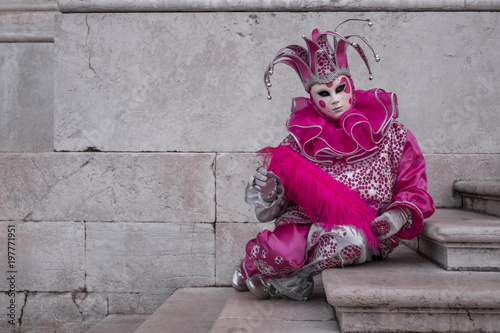 Woman dressed up as jester in pink costume at the Venice Carnival (Carnivale di Venezia)