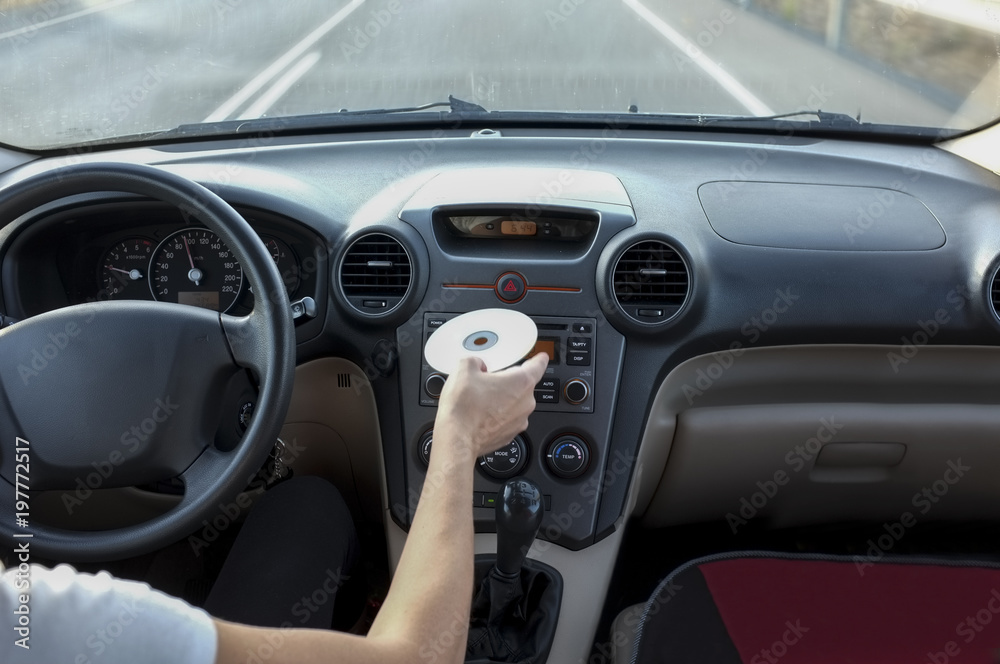 Woman inserting CD Audio while she is driving. Cause of Distracted Driving Accidents concept