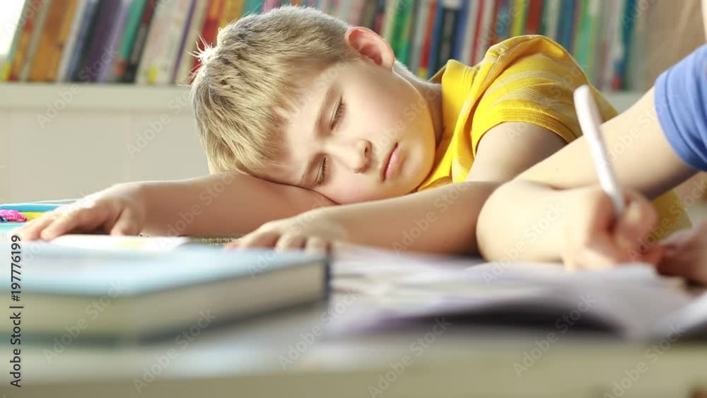 Tired schoolboy sleeping in classroom at school.
Elementary school student sleeping at classroom. Tired schoolboy sleeping in classroom at school.
Elementary school student sleeping at classroom.