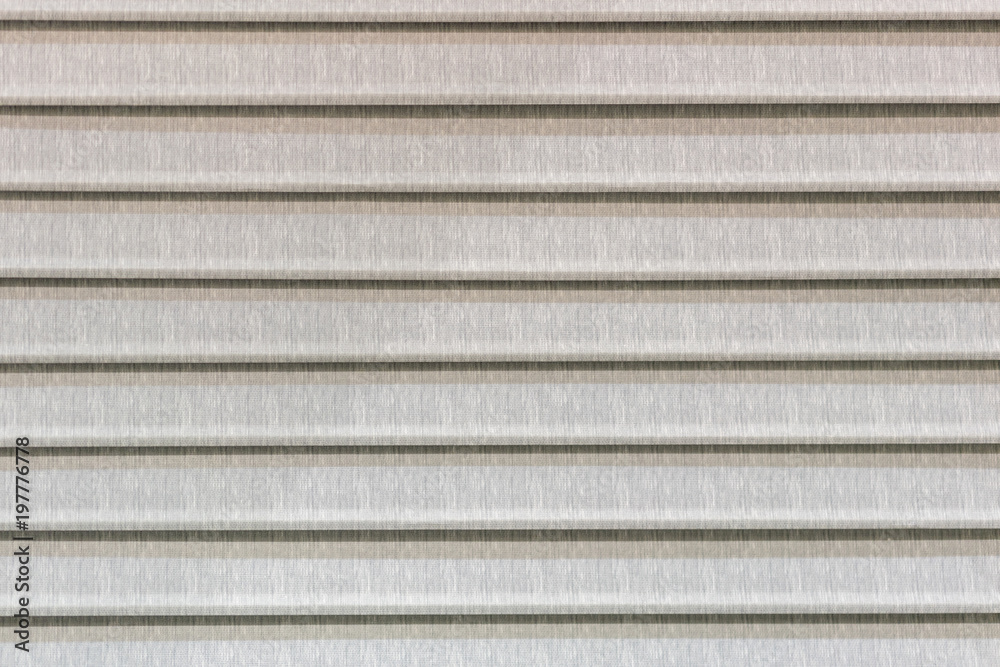 Closed blinds made of beige fabric Closed blinds made of beige fabric
