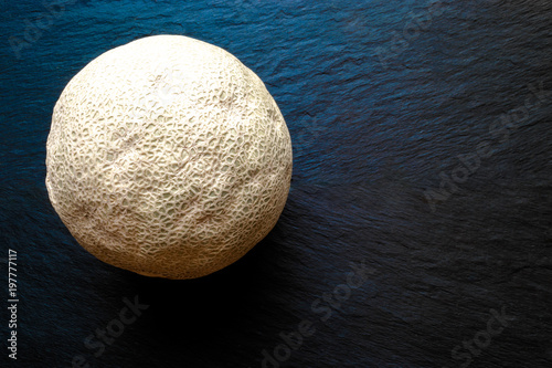 Hami Melon Fruit on Black Stone Surface Background with Free Space